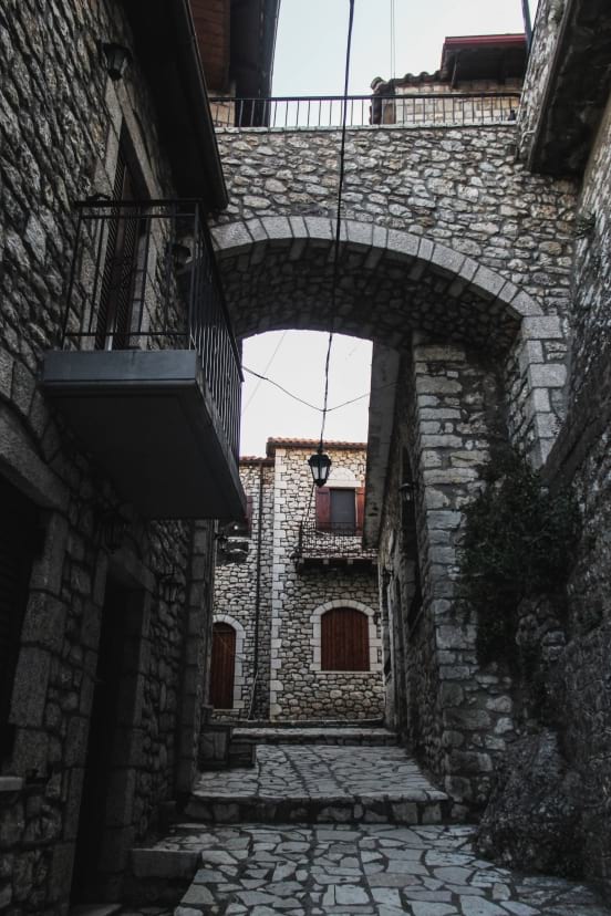 Σοκάκι με πετρόκτιστα σπίτια και πετρόκτιστο δρόμο.